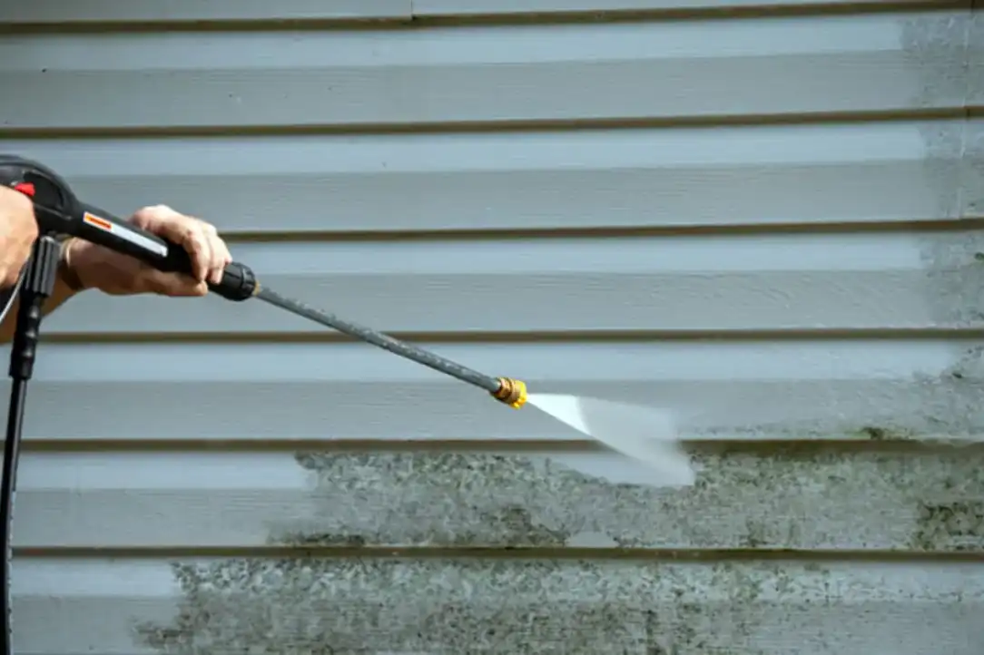 picture of someone pressure washing the exterior of a house